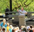 The Reptile Man holds a lizard in front of a crowd of children at the Grove Shelter in Memorial Park