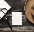 blank notebook with magnifying glass and fedora hat