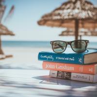 stack of books near beach with umbrellas