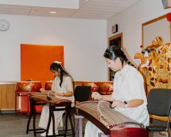 Two ladies playing Guzhengs (Traditional Harp)