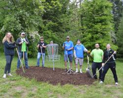 group spreading bark at disc golf course