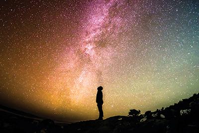 man looking up at night sky