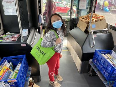 girl with bag of books on the SMART bus with book crates