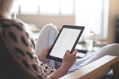 woman reading on an e-reader tablet