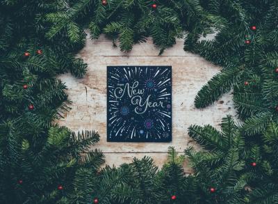 Happy New Year text surrounded by evergreen boughs