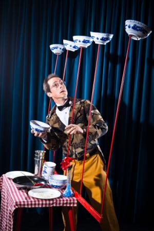 JuggleMania performing with large bowls on sticks