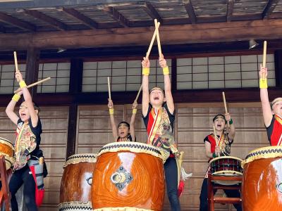 children with drumsticks playing Japanese taiko drums