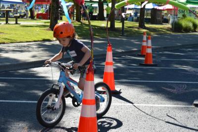 child riding bike through obstacle course