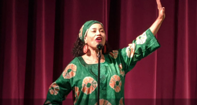 Habiba Addo performs in front of red curtain