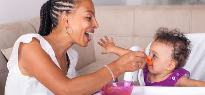 photo of mother feeding a toddler