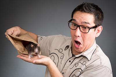 photo of Louie Foxx looking surprised while holding a paper bag with a mouse peeking out of it