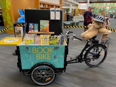 Book Bike on display in the library with a stuffed bear riding it