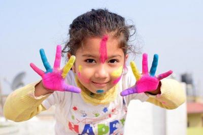 young girl with finger paint on her hands and face