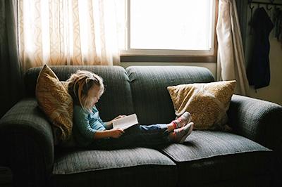 girl reading on couch