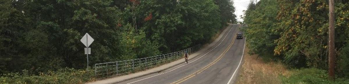 Looking west up Boeckman Rd as bike approaches, car drives uphill