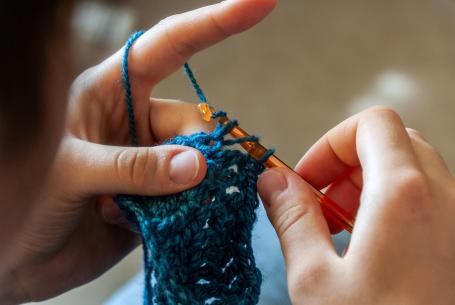 person using a crochet hook with yarn