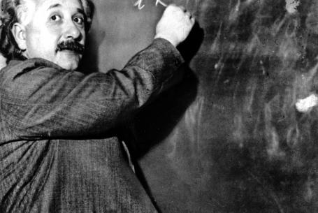 Albert Einstein writing on chalkboard