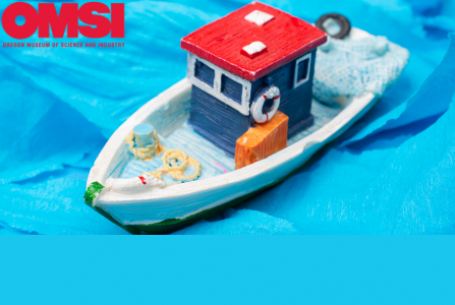 toy boat on blue torn paper water