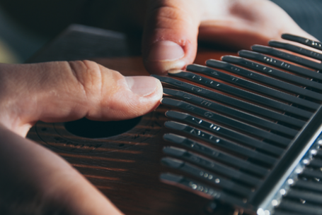 thumbs playing a kalimba