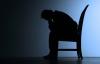 Solemn man in chair in dark  room